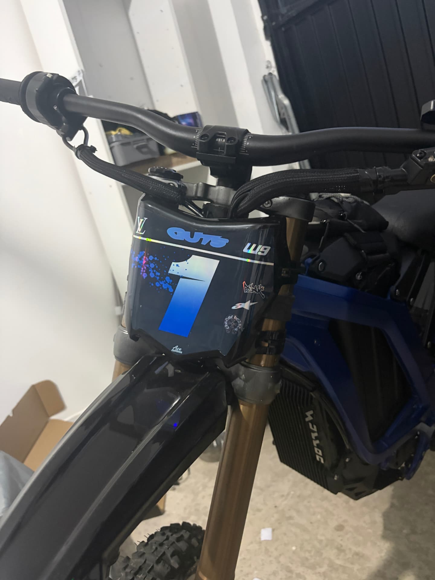 Blue holographic number board on a Talaria dirt bike